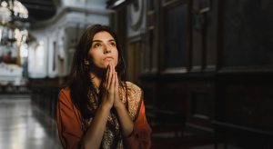 mulher orando olhando para cima e refletindo sobre Como Crescer Espiritualmente
