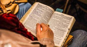 mulher idosa com a bíblia aberta procurando saber sobre lei da atração