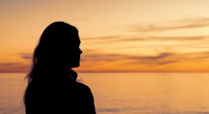 mulher refletindo sobre a vida olhando o horizonte e pensando O Que é Ser Espiritualista