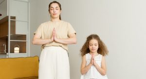 mãe e filha em pé com as mãos em oração refletindo em Como Fazer um Propósito com Deus