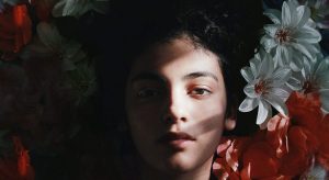 mulher deitada com flores ao lado, representando o que é uma pessoa sensitiva
