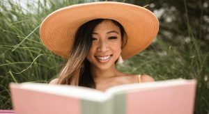mulher sorrindo lendo livro de Leitura Dinâmica e Memorização
