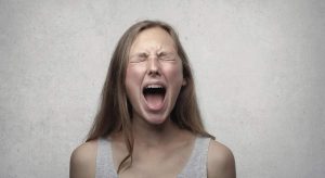 mulher nervosa gritando com pensamentos ruins simbolizando o que são pensamentos disfuncionais