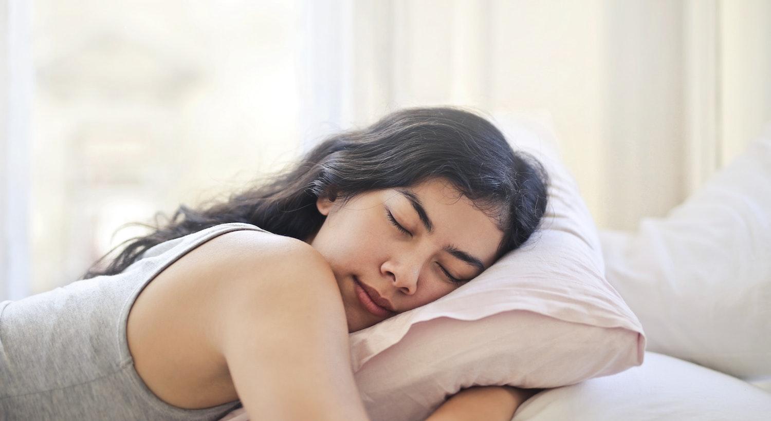 mulher dormindo com travesseiro ilustrando o tema Sonho Lúcido é Perigoso?