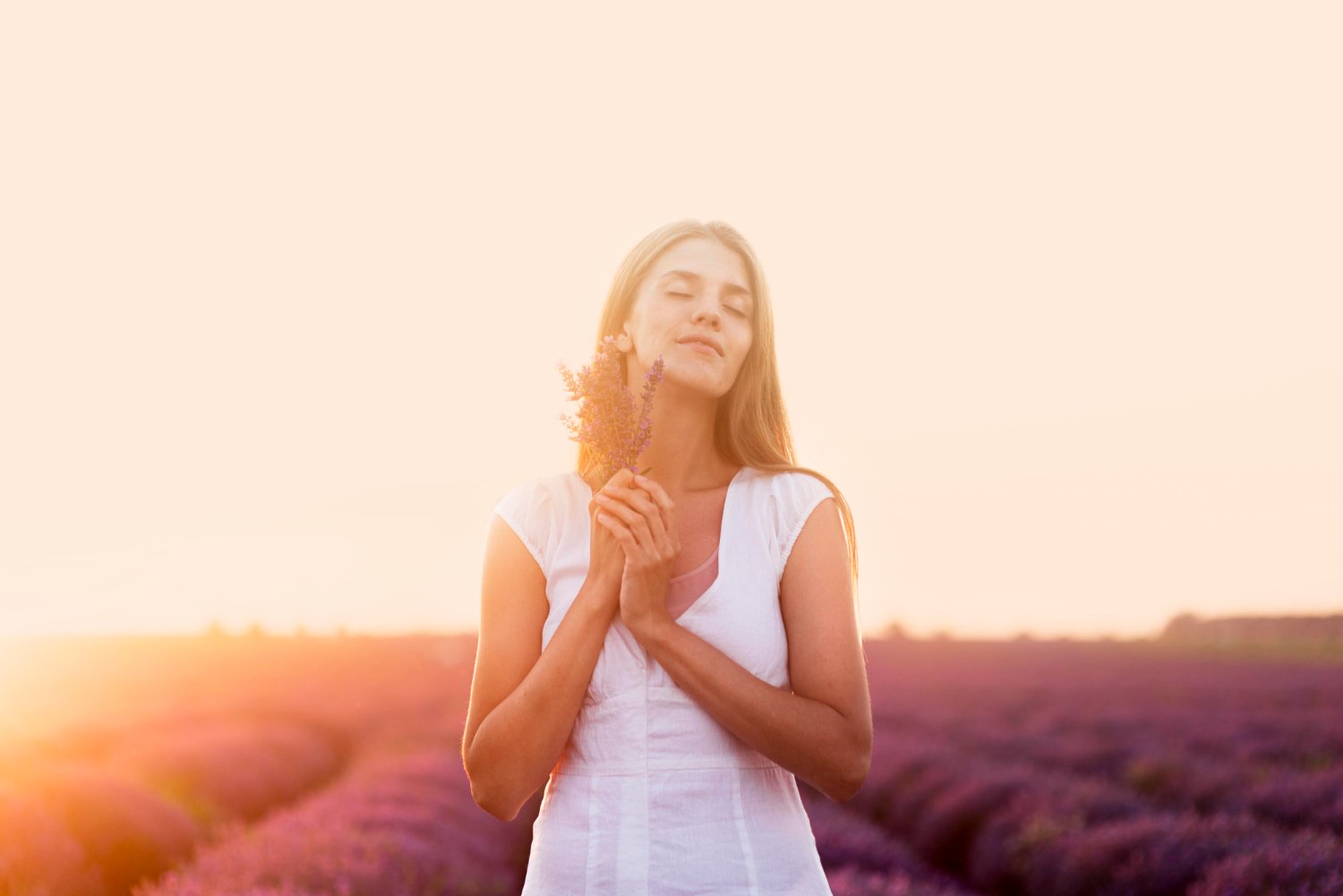 mulher no campo se sentindo feliz e meditando atraindo boas vibrações