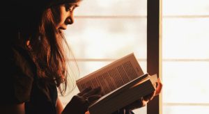 mulher lendo e refletindo sobre Como Fazer o Evangelho no Lar Sozinho